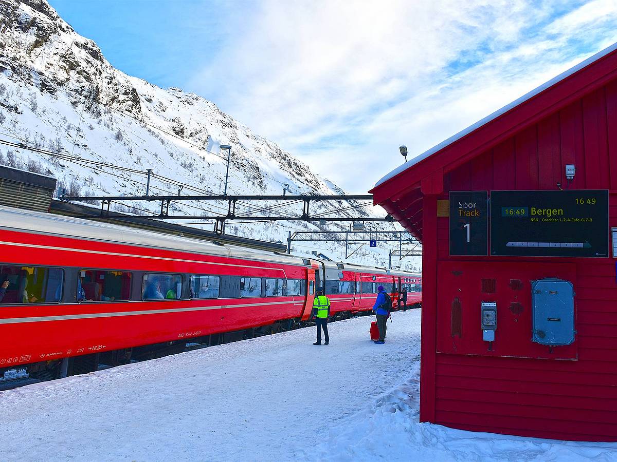 Roter Zug in verschneiter norwegischer Winterlandschaft