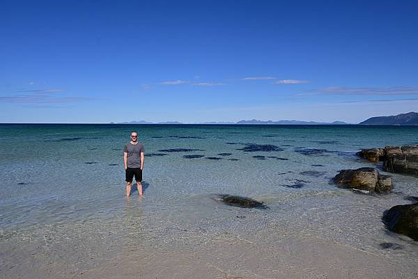 Ein Mensch im Wasser am Strand auf den Lofoten