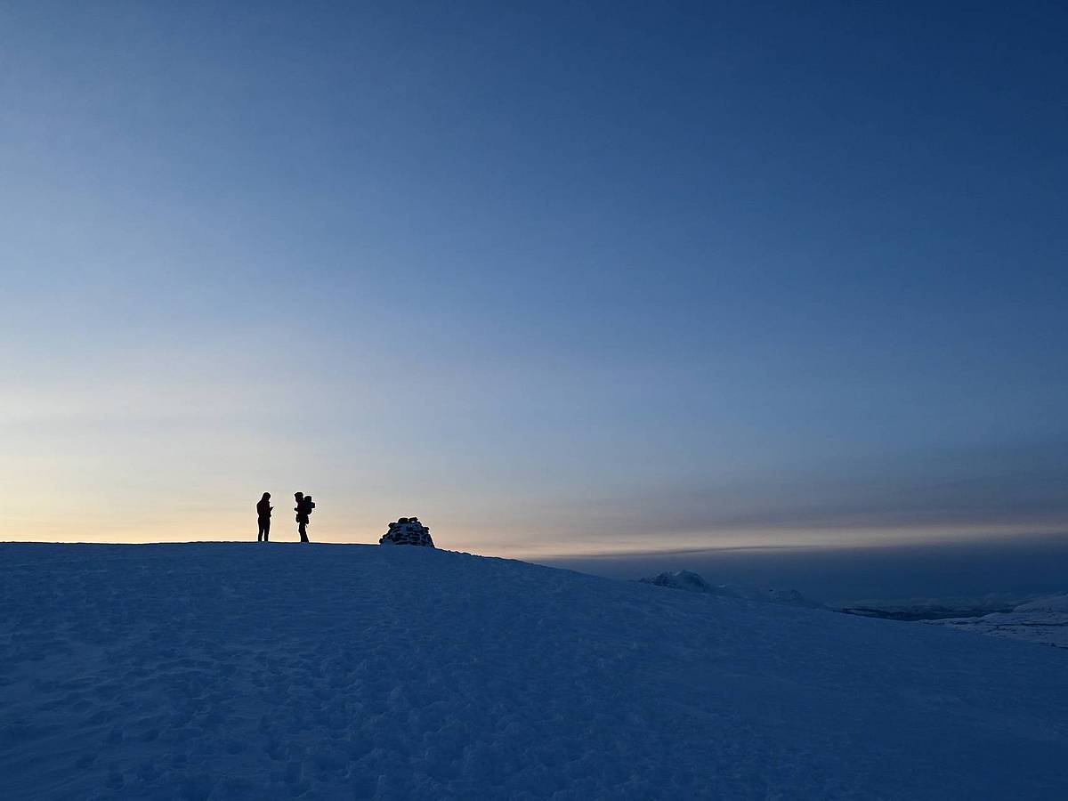 Zwei Menschen im Gegenlicht im Winter in Tromsø in Norwegen