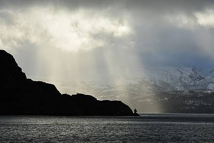 Sonnenstrahlen brechend durch die Wolken in Norwegen im Winter