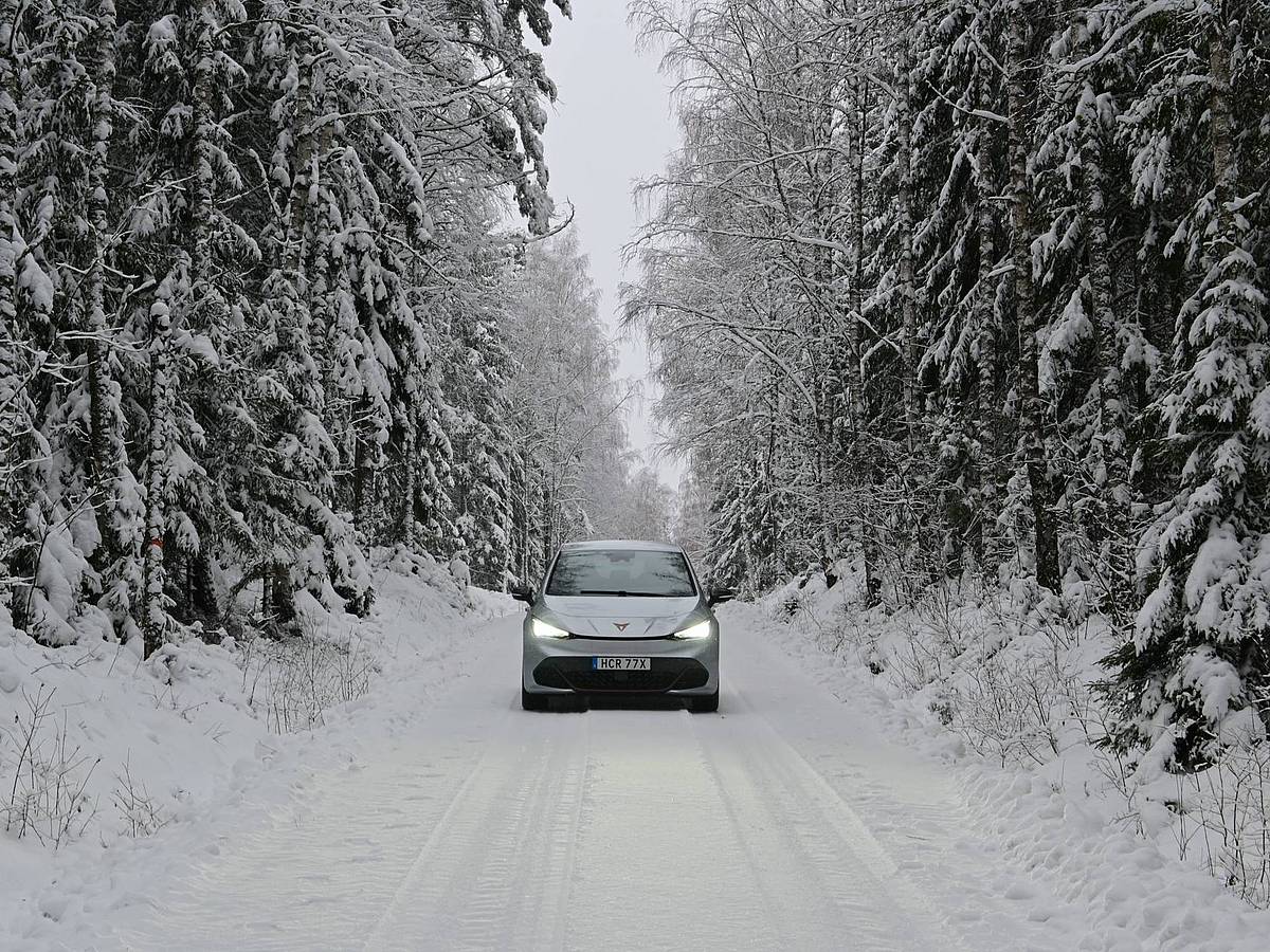 Ein E-Auto im Winter in Schweden auf einer verschneiten Straße