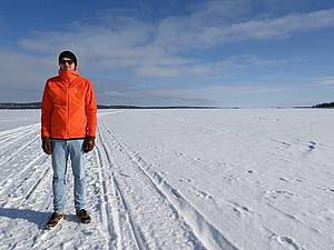 Ein Mann steht auf dem gefrorenen See in Inari in Finnland